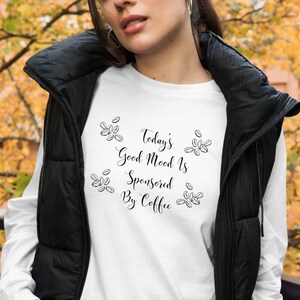 May include: White long-sleeve shirt with black text that reads "Today's Good Mood Is Sponsored By Coffee" and black coffee bean illustrations.