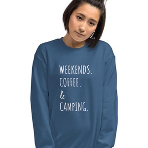 May include: A navy blue sweatshirt featuring the text "WEEKENDS. COFFEE. & CAMPING." in white. The sweatshirt has a crew neck and is a solid colour.