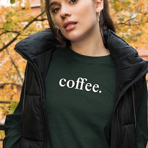 May include: A dark green long-sleeved shirt with the word "coffee" printed in white on the front.