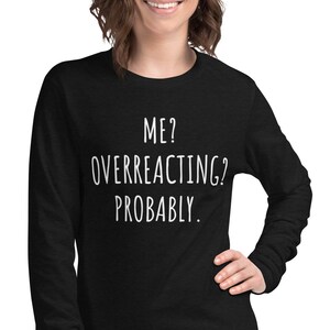 May include: Black long-sleeve shirt with white text that reads "ME? OVERREACTING? PROBABLY."
