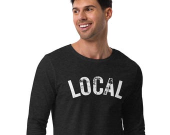 May include: A dark grey long-sleeve t-shirt with the word "LOCAL" printed in white on the front. The text has a distressed, vintage look.