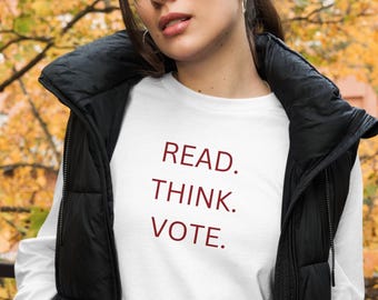 May include: White long-sleeve shirt with the text "READ. THINK. VOTE." printed in maroon.