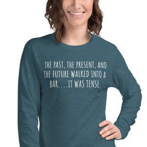 May include: A teal blue long-sleeved shirt with white text that reads "THE PAST, THE PRESENT, AND THE FUTURE WALKED INTO A BAR....IT WAS TENSE."