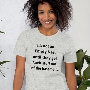May include: A heather grey t-shirt with the text "It's not an Empty Nest until they get their stuff out of the basement."