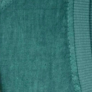 Pu&ograve; includere: Un capo di abbigliamento verde ottanio caratterizzato da una superficie in tessuto intrecciato e testurizzato. Il pezzo presenta un dettaglio a coste sul colletto o sul bordo, con cuciture visibili che collegano la sezione a coste al corpo principale.