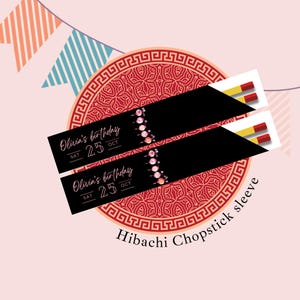 May include: Two black chopstick sleeves with the text "Olivia's birthday" and the date "25 OCT" are displayed over a red patterned circle. The sleeves have a floral design and are paired with chopsticks. The words "Hibachi Chopstick sleeve" are at the bottom.