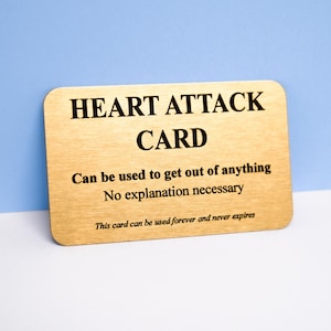May include: A rectangular gold-colored metal card with rounded corners featuring black text that reads: HEART ATTACK CARD, Can be used to get out of anything, No explanation necessary, This card can be used forever and never expires.