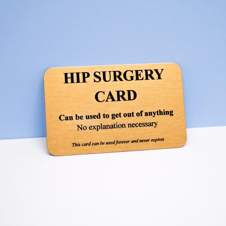 Op de afbeelding: Een rechthoekige goudkleurige metalen kaart met afgeronde hoeken en zwarte tekst: HIP SURGERY CARD, Can be used to get out of anything, No explanation necessary, This card can be used forever and never expires.