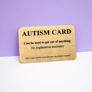 May include: A rectangular gold-toned metal card with rounded corners featuring black text that reads: AUTISM CARD, Can be used to get out of anything, No explanation necessary, This card can be used forever and never expires.