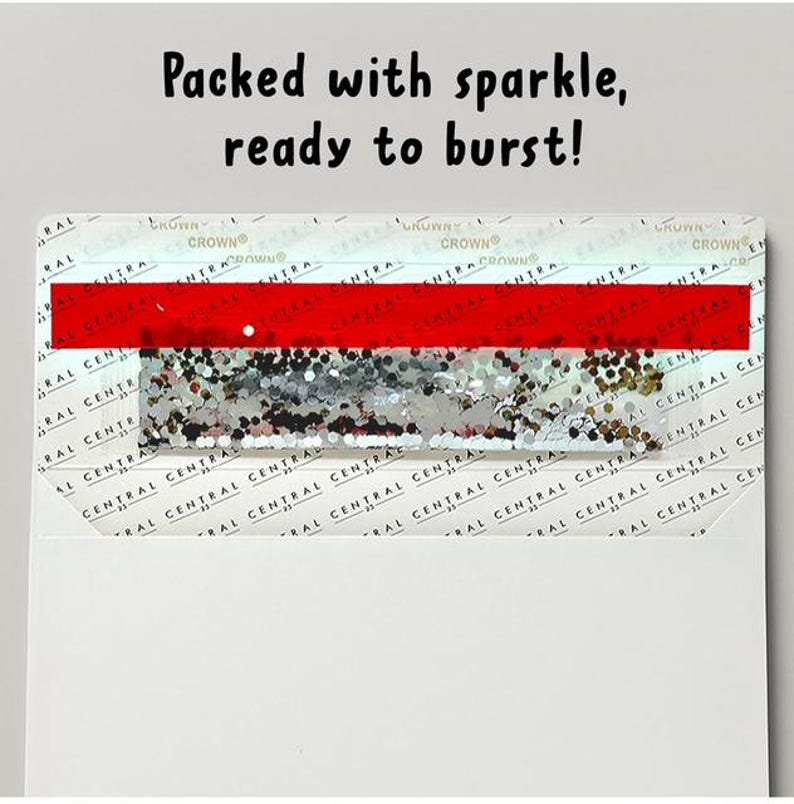 Op de afbeelding: Een witte envelop met een rechthoekige kaart met de tekst Packed with sparkle, ready to burst! De kaart heeft een horizontale rode streep boven een sectie gevuld met zilveren en gouden glitters, tegen een achtergrond van het herhalende Central Crown logo.