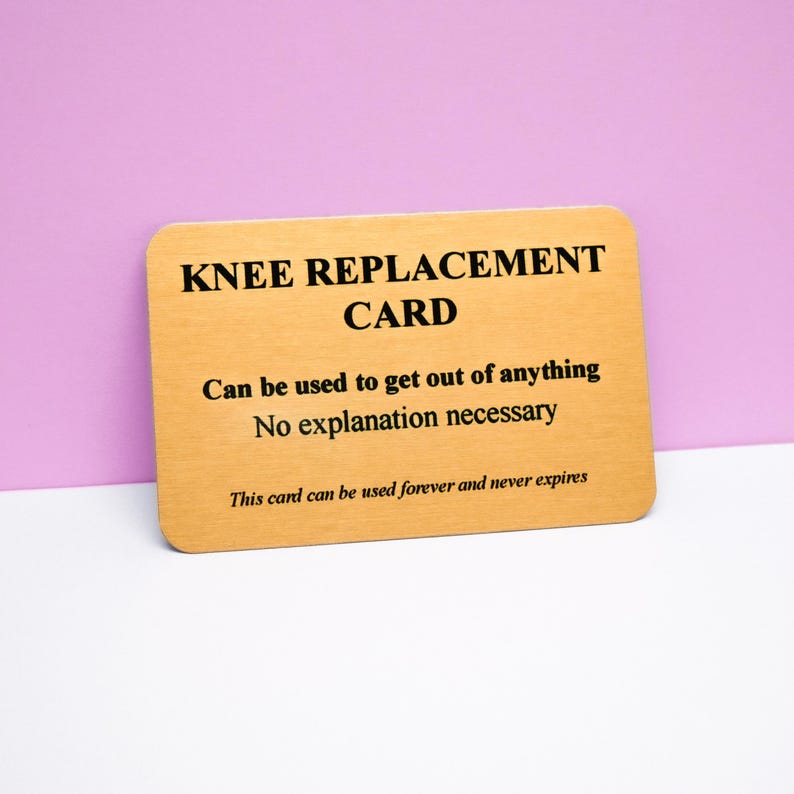 Op de afbeelding: Een rechthoekige goudkleurige kaart met afgeronde hoeken en zwarte tekst die luidt: KNEE REPLACEMENT CARD, Can be used to get out of anything, No explanation necessary, This card can be used forever and never expires.