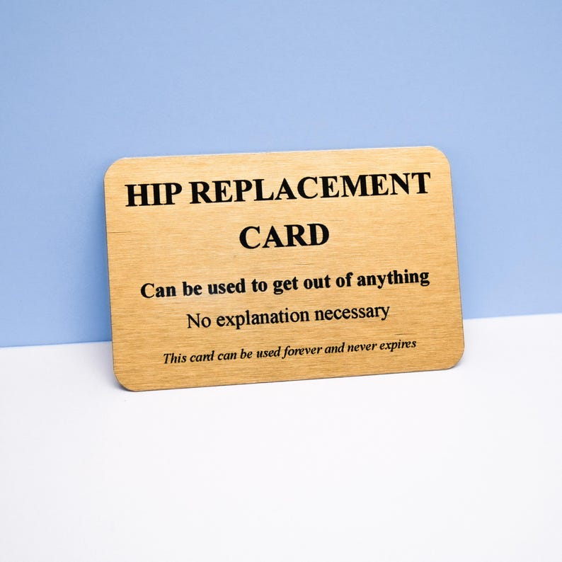 Op de afbeelding: Een rechthoekige, lichtgekleurde houten kaart met afgeronde hoeken en zwarte tekst: HIP REPLACEMENT CARD, Can be used to get out of anything, No explanation necessary, This card can be used forever and never expires.
