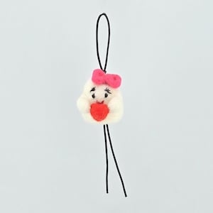May include: A small, white, needle-felted ghost ornament featuring a bright pink bow on its head and a red heart held in its arms. The ghost has embroidered black eyes and a mouth, and it is attached to a thin black cord for hanging purposes.