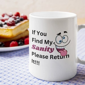以下が含まれることがあります： 「If You Find My Sanity Please Return It!!!」の文字と漫画の顔が描かれた白いセラミックマグ。背景にはベリーを添えたフレンチトーストが盛られたお皿があります。