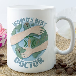 May include: White ceramic mug with a blue and green illustration of the world being hugged by two arms. The text "WORLD'S BEST DOCTOR" is printed on the mug.