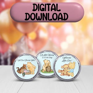 May include: Three Winnie the Pooh themed chocolate wrappers with blue backgrounds. The wrappers feature Winnie the Pooh and Tigger. The text on the wrappers reads "We Can Bearty Wait", "A Little Hunny is on the way", and "Welcome Little One!"