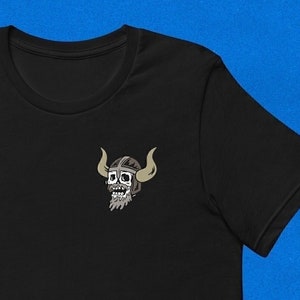 May include: Black t-shirt with a small embroidered image of a skull wearing a helmet with horns.