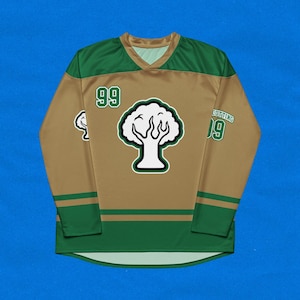 May include: A gold and green hockey jersey with a tree logo and the number 99 on the front. The jersey has a green and gold stripe pattern on the sleeves.