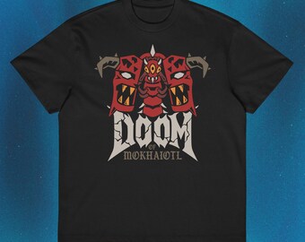 Pode incluir: Uma t-shirt preta de manga curta com uma estampa gráfica de uma criatura vermelha de vários olhos com chifres. Abaixo da criatura, o texto DOOM OF MOKHAIOTL aparece numa fonte branca desgastada e irregular no peito da t-shirt.