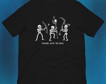 Pode incluir: Uma t-shirt preta de manga curta com um gráfico branco de três esqueletos em poses de ação. Um esqueleto segura um arco, outro um cajado com um orbe brilhante e outro uma foice. O texto "RAIDING WITH THE BOYS" está impresso abaixo deles.