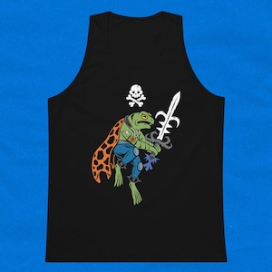 May include: Black tank top with a graphic of a green frog wearing a blue and orange outfit, holding a sword and a skull and crossbones symbol above it.