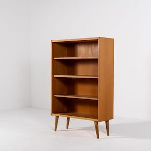 Puede incluir: Estanter&iacute;a de madera marr&oacute;n claro con cuatro estantes. La estanter&iacute;a tiene forma rectangular y est&aacute; sostenida por cuatro patas anguladas. Los estantes est&aacute;n espaciados uniformemente y el dise&ntilde;o es simple y funcional.