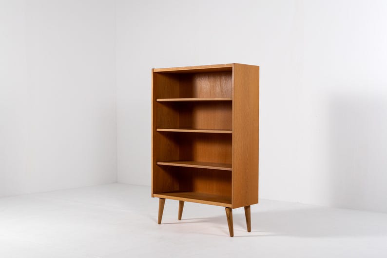 Puede incluir: Estanter&iacute;a de madera marr&oacute;n claro con cuatro estantes. La estanter&iacute;a tiene forma rectangular y est&aacute; sostenida por cuatro patas anguladas. Los estantes est&aacute;n espaciados uniformemente y el dise&ntilde;o es simple y funcional.