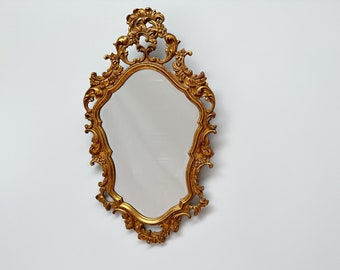Vintage ingelijste vergulde spiegel met sierlijk decor en afgeschuind glas