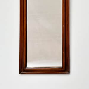 May include: A tall, rectangular mirror with a dark wood frame. The frame has a simple, traditional design.