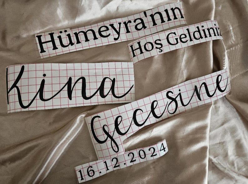 May include: Black vinyl lettering decals on a white grid transfer paper. The text reads H&uuml;meyra'nın Hoş Geldiniz Kına Gecesine and the date 16.12.2024. The decals feature a mix of bold serif and elegant script fonts for custom application.