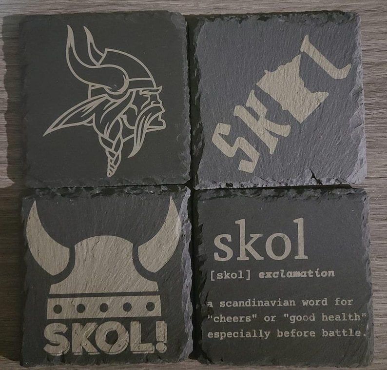 May include: Four black slate coasters featuring a Viking helmet and the word "SKOL!" engraved on them. The coasters also include the definition of the word "skol" as a Scandinavian word for "cheers" or "good health", especially before battle.