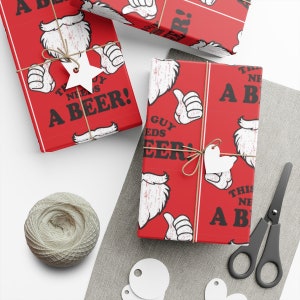 May include: Red wrapping paper with a repeating pattern of a white beard, thumbs up, and the text "THIS GUY NEEDS A BEER!". The wrapped gifts are tied with twine and adorned with white tags. A spool of twine and scissors are also visible.