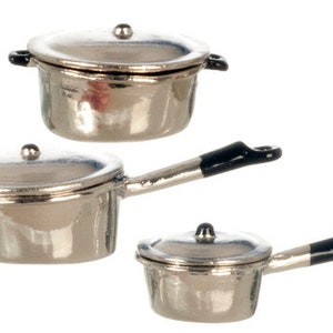 May include: Set of three silver-colored miniature pots with black handles and lids. The pots are arranged in descending size order.