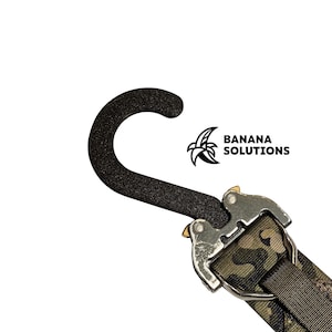 May include: A black and green camouflage strap with a metal buckle and a black padded hook. The strap has the text "BANANA SOLUTIONS" printed on it.