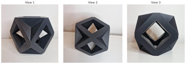 May include: A dark gray geometric sculpture with a multifaceted design. The sculpture has open spaces and angular shapes, creating a modern and abstract aesthetic. The object is displayed on a white surface.