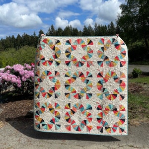 A beautiful Mahalo quilt throw featuring curved pieced blocks of the Desert Bloom designer fabrics in desert themed prints.