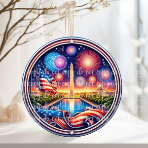 May include: A round, red, white, and blue Christmas ornament featuring a depiction of the Washington Monument and fireworks over the National Mall in Washington, D.C.
