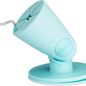 Puede incluir: Un soporte para tel&eacute;fono de color azul claro con un brazo articulado y una base de ventosa. El soporte tiene la palabra "Hinge" impresa en el lateral.