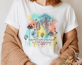 May include: White t-shirt with a watercolor design of flowers and the text "His mercies are new every morning" Lamentations 3:23.
