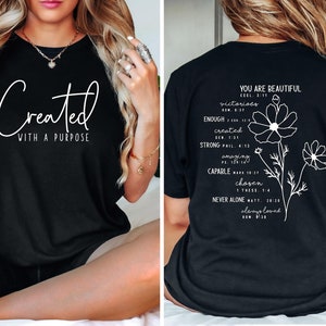 May include: Black t-shirt with white text that reads "Created with a purpose" on the front and "You are beautiful" with a list of encouraging words and bible verses on the back.