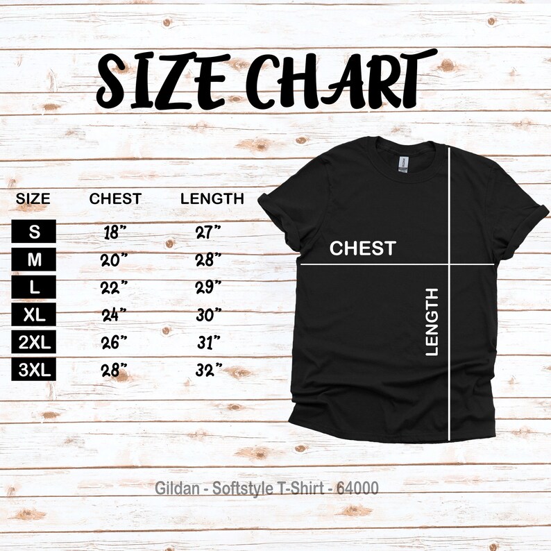 Puede incluir: Tabla de tallas para una camiseta Gildan Softstyle, que muestra las medidas de pecho y longitud en pulgadas para las tallas S, M, L, XL, 2XL y 3XL. La tabla est&aacute; impresa sobre un fondo de madera.