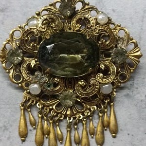 Gilded vintage brooch with stone. image 1