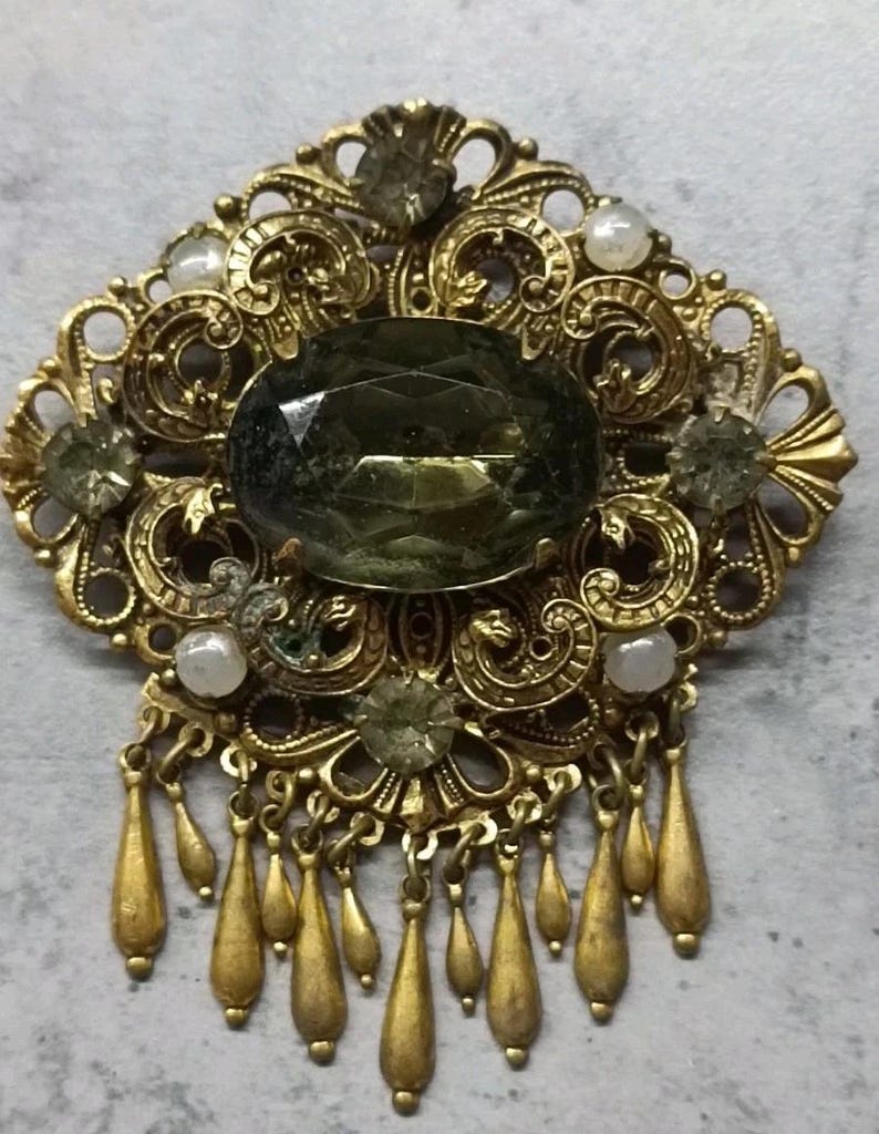 Gilded vintage brooch with stone. image 1