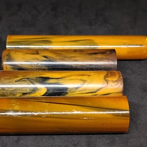 May include: Four round, polished, brown and gold marbled acrylic rods.