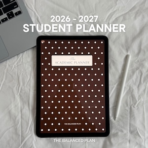 Può includere: Un tablet digitale che mostra un'agenda per studenti 2026-2027 con sfondo marrone scuro e pois bianchi. Lo schermo presenta il testo The Academic Planner e The Balanced Plan. Un computer portatile e uno stilo bianco sono posizionati vicino.
