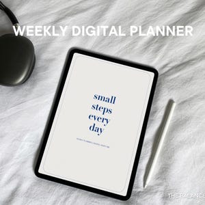 May include: A white digital planner with a black border and the text "small steps every day" on a white background. The planner is lying on a white surface with a white stylus and a pair of black headphones.