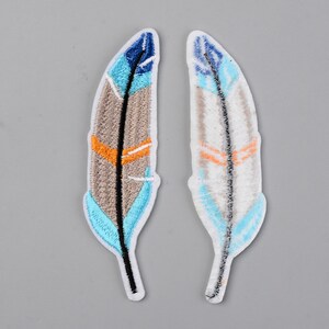 May include: Two embroidered iron-on patches featuring colorful feathers with blue, white, orange, and brown details.