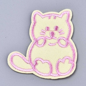 May include: A pink embroidered iron-on patch of a cartoon cat with a light yellow background.