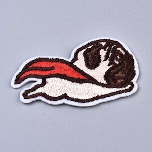 May include: Embroidered iron-on patch of a brown and white pug wearing a red cape. The pug is lying on its side with its tongue sticking out.