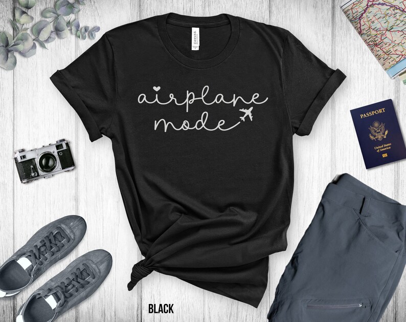 Puede incluir: Camiseta negra con texto blanco que dice "modo avi&oacute;n" y un peque&ntilde;o icono de avi&oacute;n.